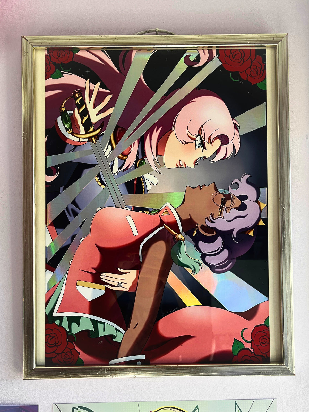 A framed anime art print featuring characters from Revolutionary Girl Utena, displayed on a light-colored wall above other colorful art pieces.