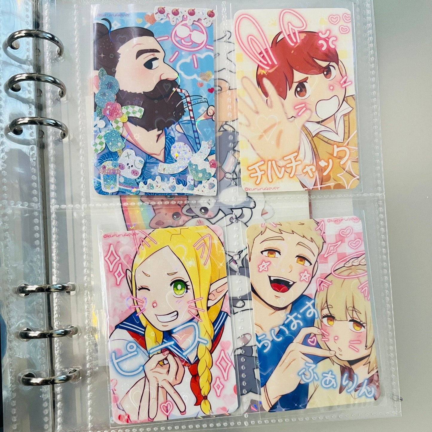 4 photocards of Marcille, Senshi, Laios, Falin and Chilchuck from Delicious in Dungeon in a binder